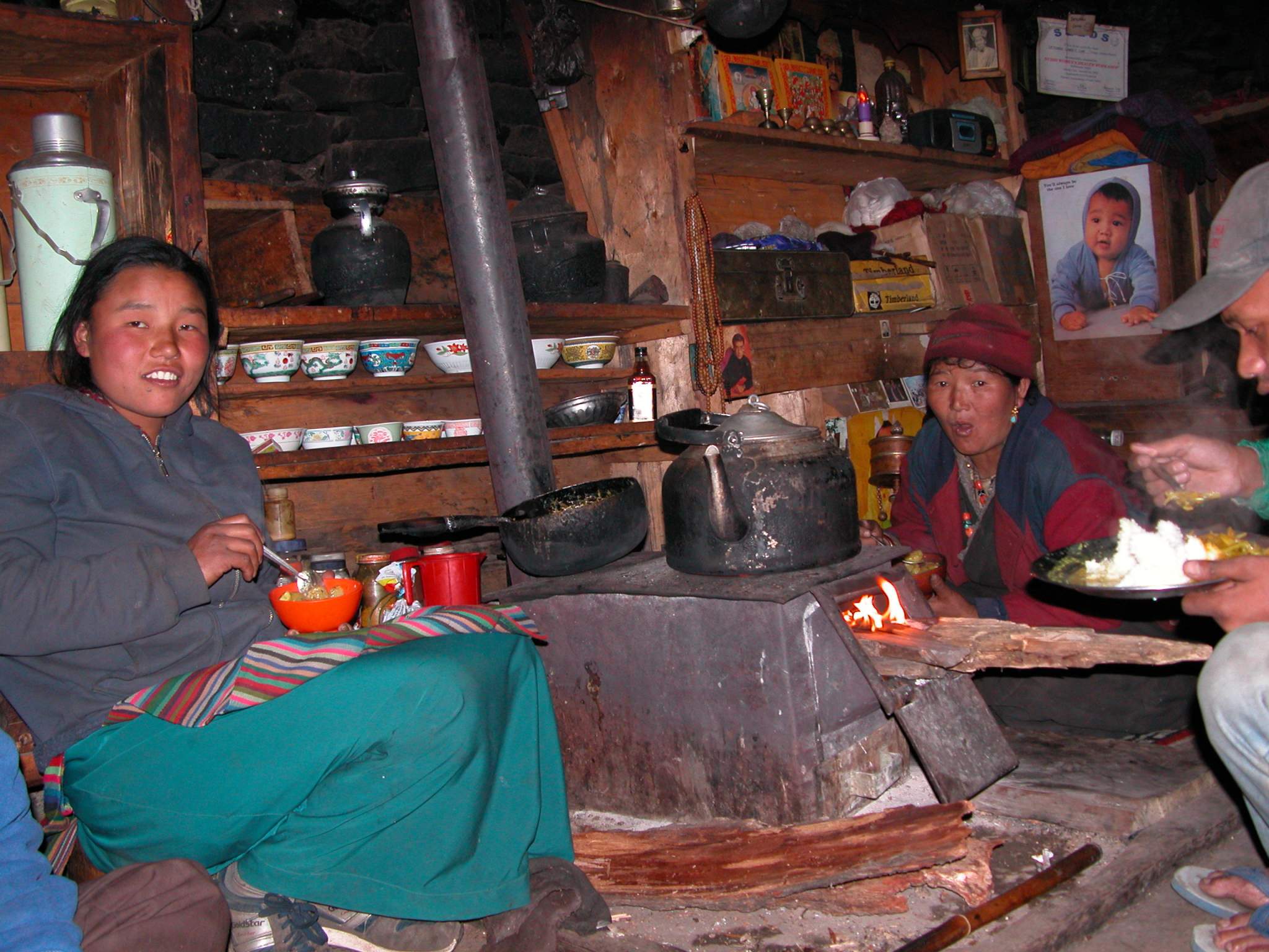 Manaslu 06 10 Syala Mother and Daughter In Lodge The campsite was already occupied by a Spanish group, so we stayed at the Maili Manaslu Hotel, Shyala, Gorkha. The lodge is being run by a mother and her daughter. The girl laughs liberally while mom sits silent, but smiling. I ate my dinner of rice and vegetable curry (hey, this isn't daal baht, is it), I watched as the girl cut mini-potatoes and fried them in a cast iron type pan on a small wood stove. I told her that potatoes were my favourite. She offered me a bowl, which I gratefully accepted. They were fantastic, though a bit spicy.
